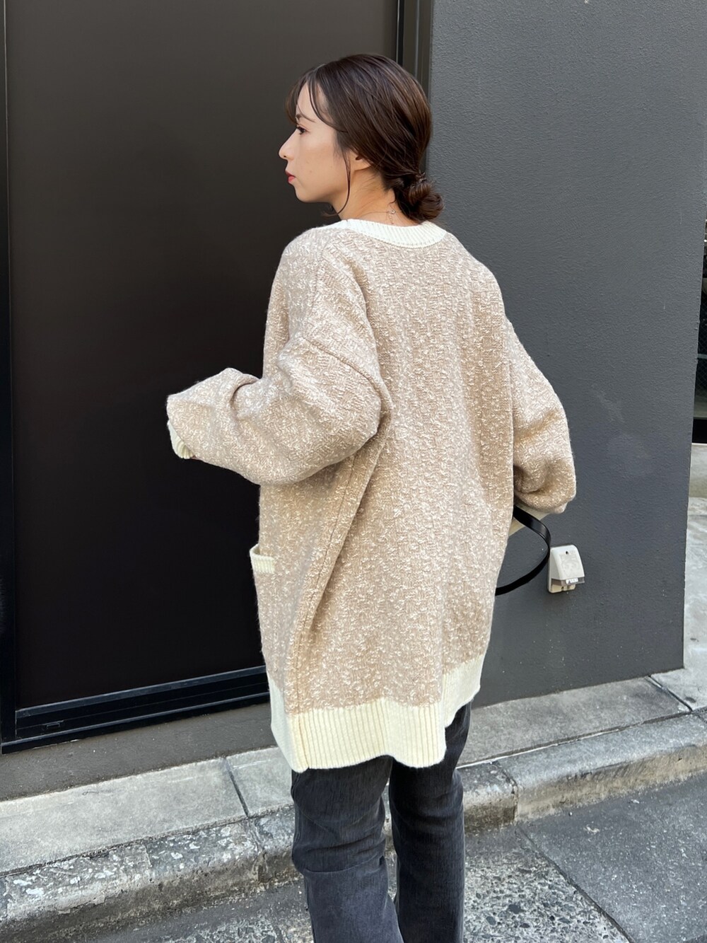 ベージュ系のカーディガン/ボレロ、ホワイト系のニット/セーター、ブラック系のデニムパンツを着用したレディースの秋コーディネートの5枚目の写真