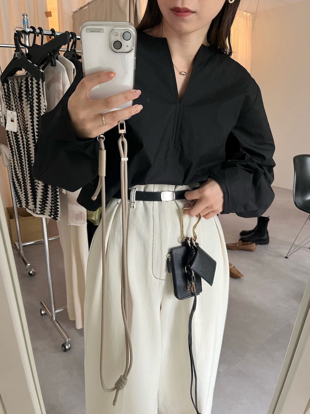 ホワイト系のデニムパンツ、ブラック系のシャツ/ブラウス、ホワイト系のシューズを着用したレディースの春コーディネートの4枚目の写真