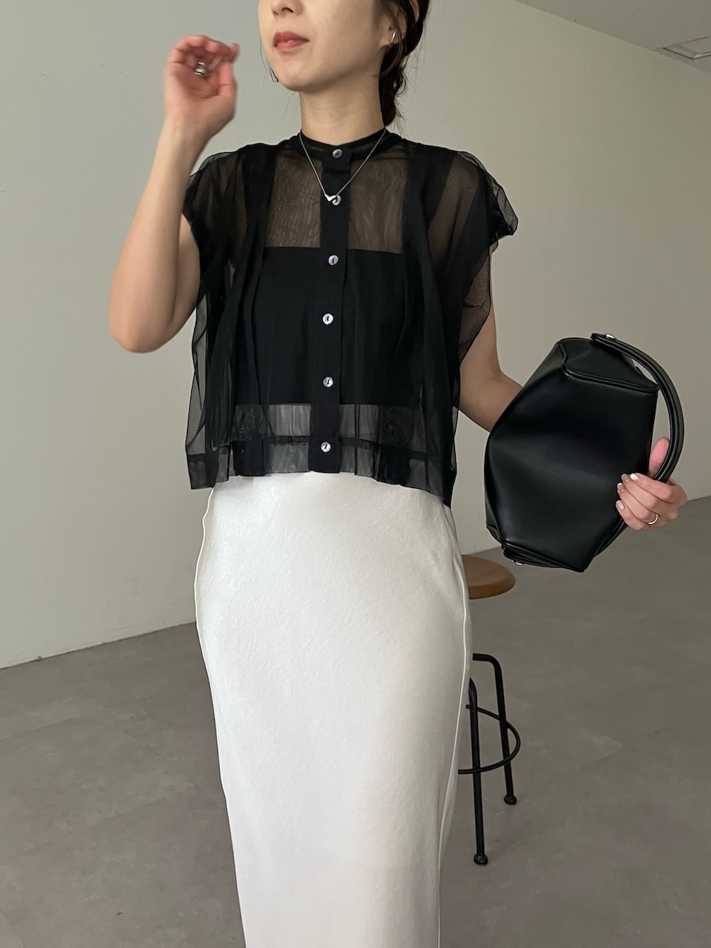 ホワイト系のスカート、ブラック系のシャツ/ブラウス、ブラック系のショルダーバッグを着用したレディースの夏コーディネートの3枚目の写真
