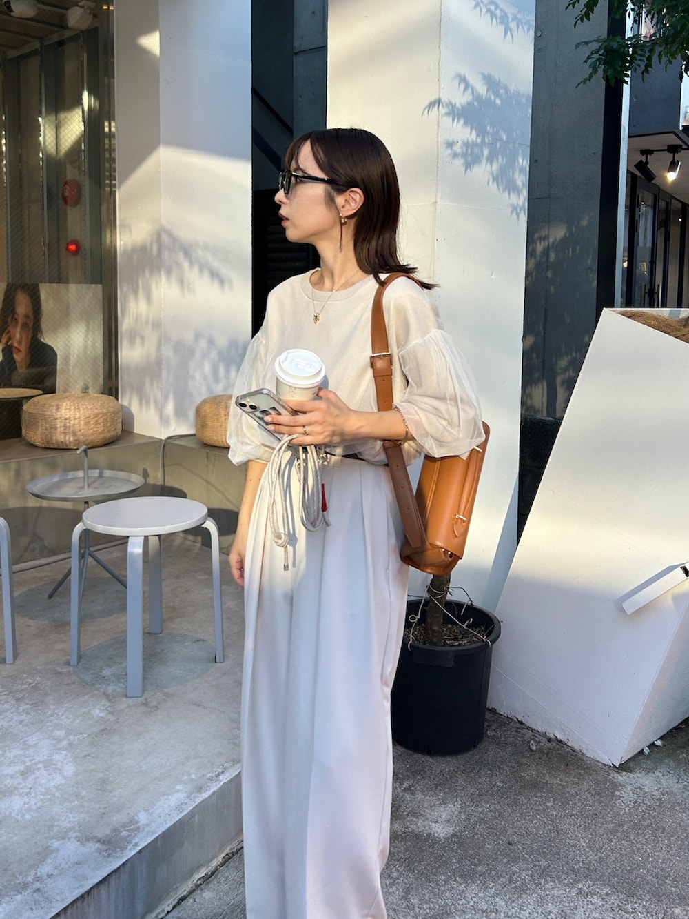 ベージュ系のニット/セーター、ホワイト系のその他パンツ、ブラック系のブーツを着用したレディースの秋コーディネートの6枚目の写真