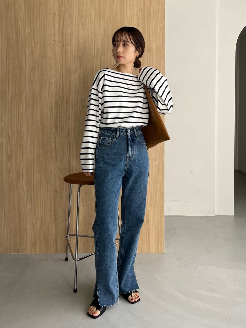 ホワイト系のニット/セーター、ブルー系のデニムパンツ、ブラック系のサンダルを着用したレディースの冬コーディネートの2枚目の写真