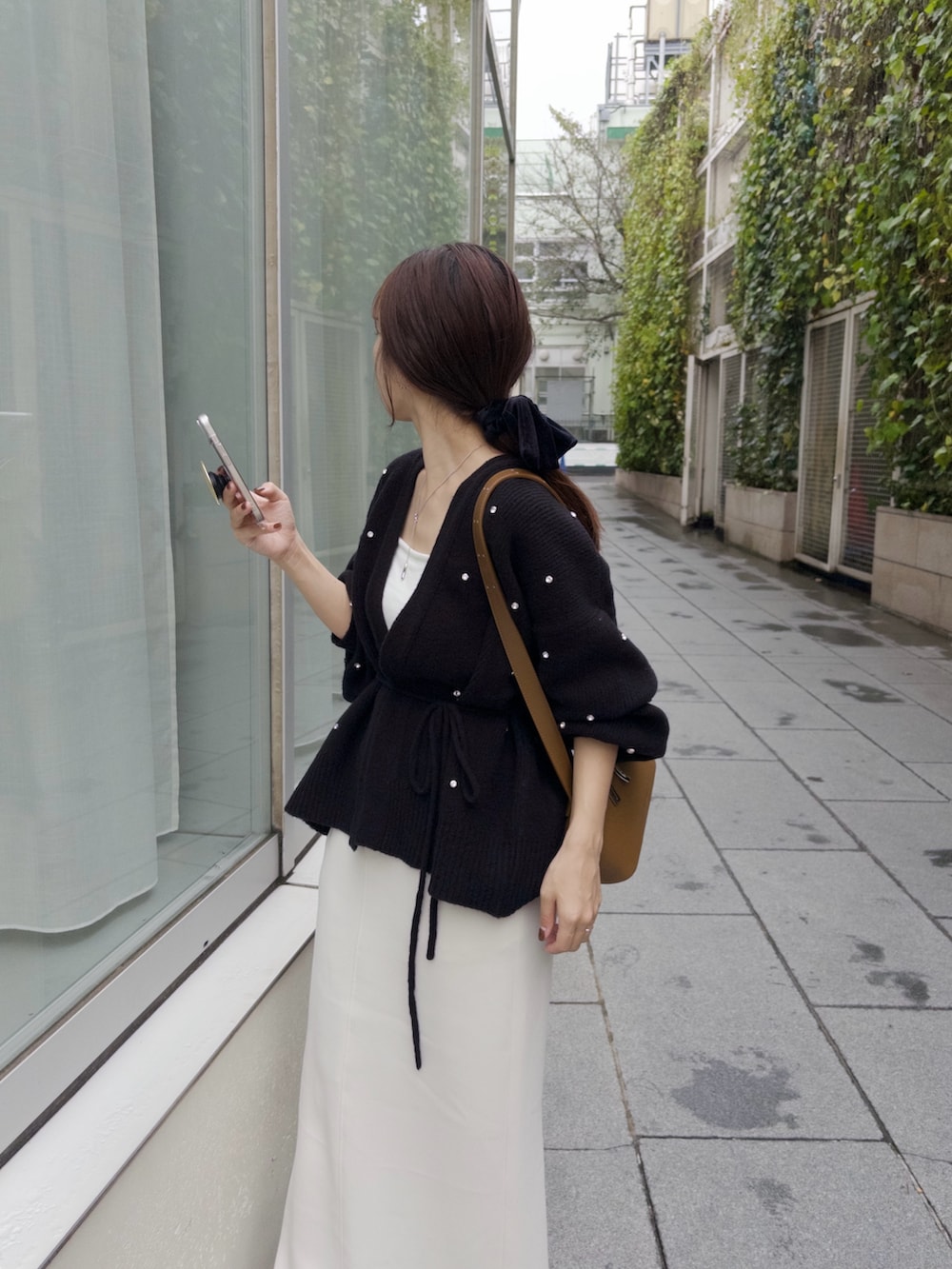 ホワイト系のスカート、ブラック系のカーディガン/ボレロ、イエロー系のショルダーバッグを着用したレディースの秋コーディネートの4枚目の写真