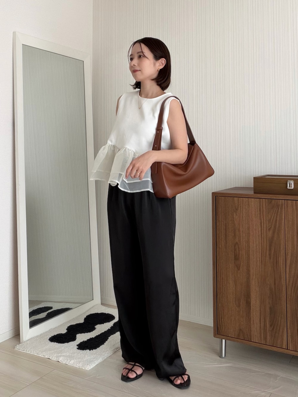 ブラック系のその他パンツ、ホワイト系のTシャツ/カットソー、ブラウン系のバッグを着用したレディースの夏コーディネートの2枚目の写真