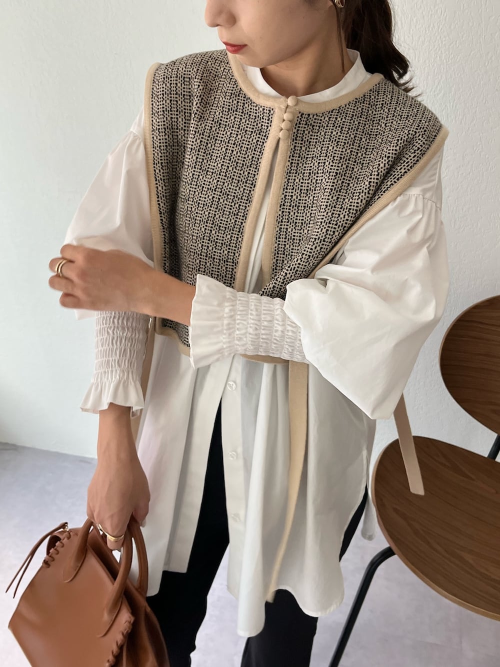 ベージュ系のニット/セーター、ホワイト系のシャツ/ブラウス、ブラウン系のトートバッグを着用したレディースの夏コーディネートの4枚目の写真