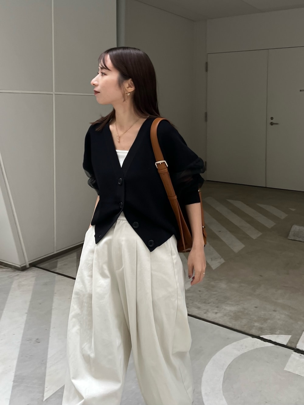 ホワイト系のその他パンツ、ブラック系のカーディガン/ボレロ、ベージュ系のショルダーバッグを着用したレディースの春コーディネートの4枚目の写真