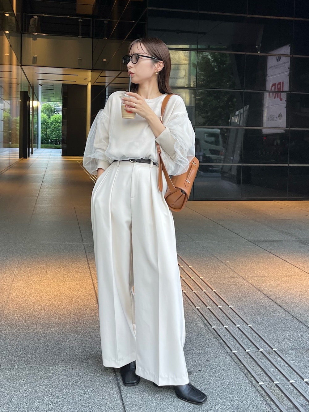 ベージュ系のニット/セーター、ホワイト系のその他パンツ、ブラック系のブーツを着用したレディースの秋コーディネートの2枚目の写真