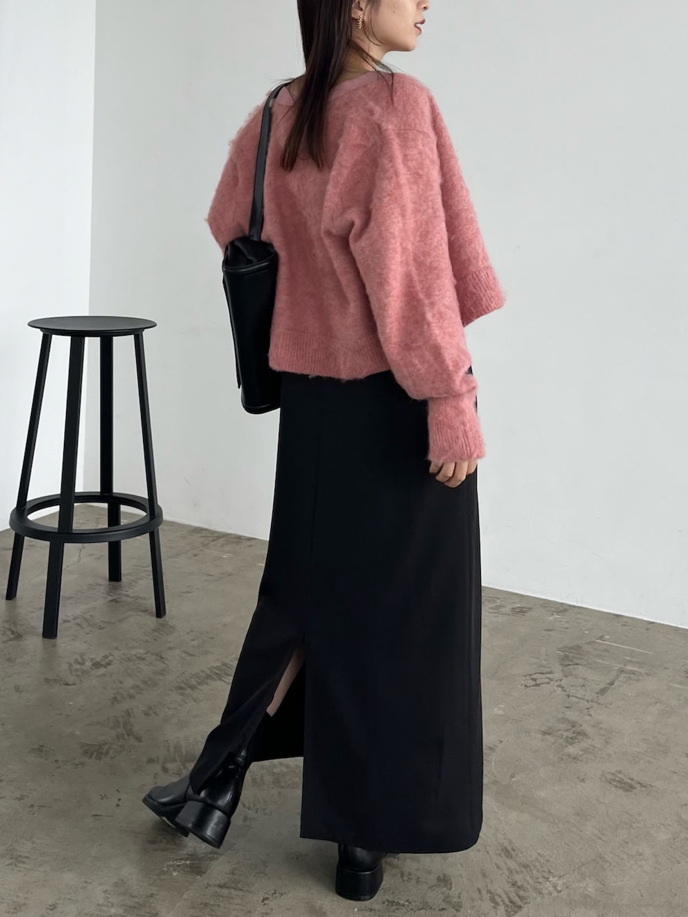 ブラック系のワンピース、ブラック系のパンプス、ブラック系のショルダーバッグを着用したレディースの秋コーディネートの3枚目の写真