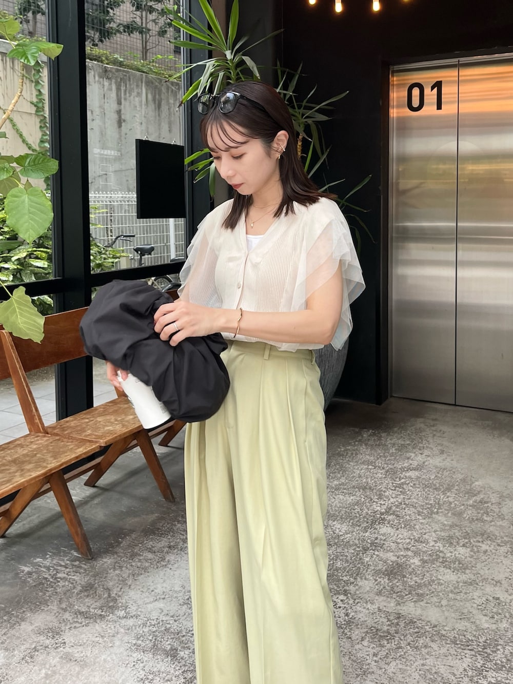 グリーン系のその他パンツ、ベージュ系のニット/セーター、ブラック系のショルダーバッグを着用したレディースの夏コーディネートの2枚目の写真