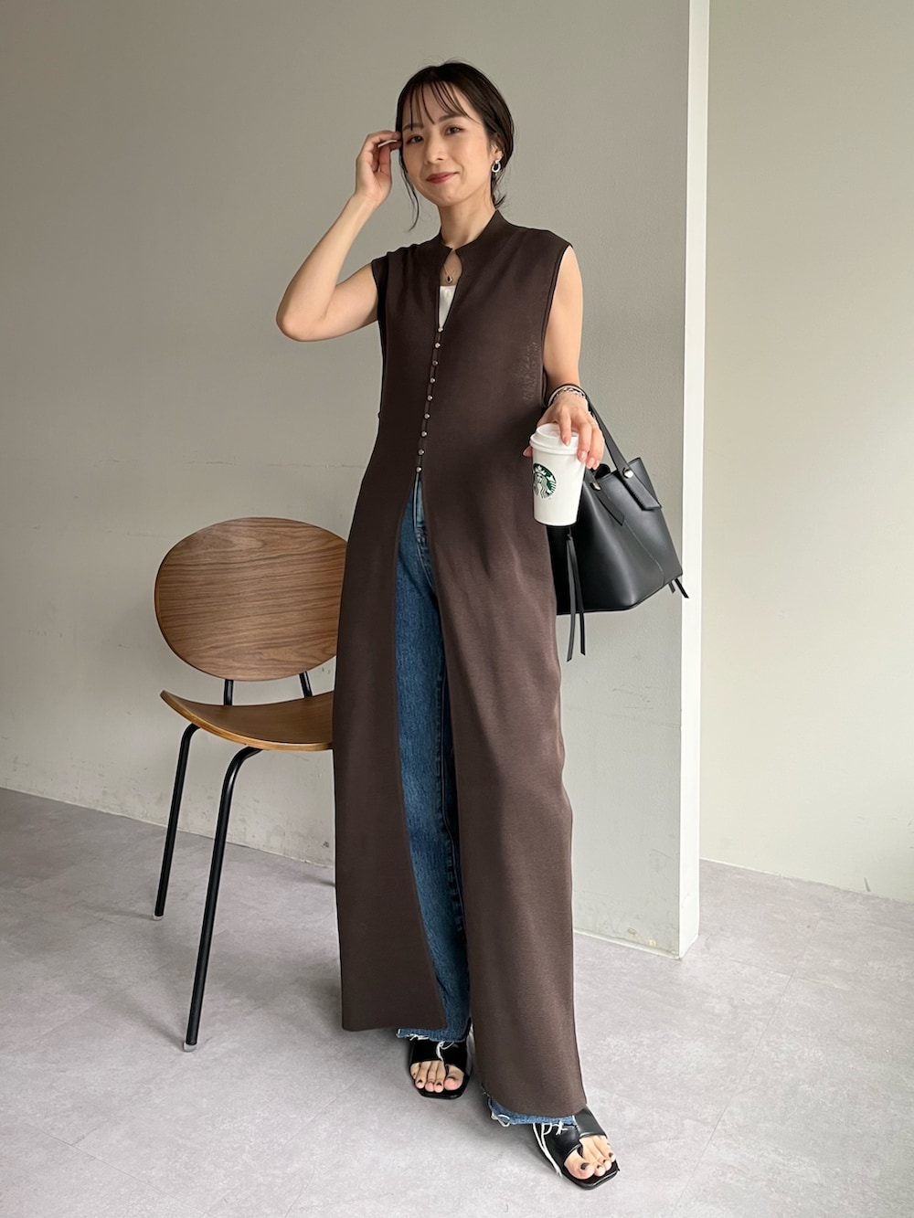 ブラウン系のワンピース/ドレス、ブルー系のデニムパンツ、ブラック系のサンダルを着用したレディースの春コーディネートの5枚目の写真