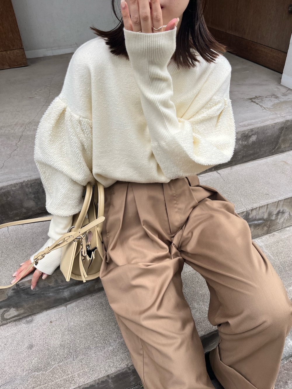 ベージュ系のバッグ、ホワイト系のニット/セーター、ブラウン系のその他パンツを着用したレディースの秋コーディネートの4枚目の写真