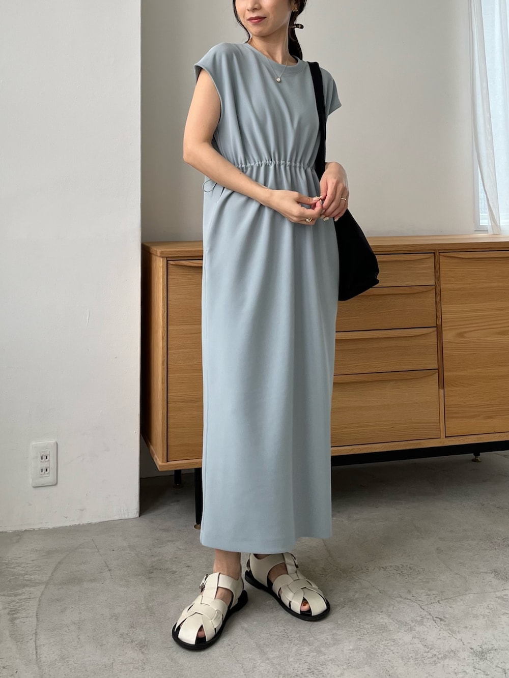 ブルー系のワンピース/ドレス、ブラック系のショルダーバッグ、ホワイト系のサンダルを着用したレディースの春コーディネートの3枚目の写真