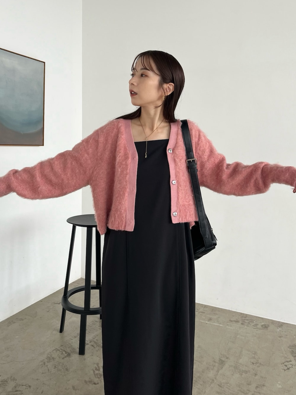 ブラック系のワンピース、ブラック系のパンプス、ブラック系のショルダーバッグを着用したレディースの秋コーディネートの4枚目の写真