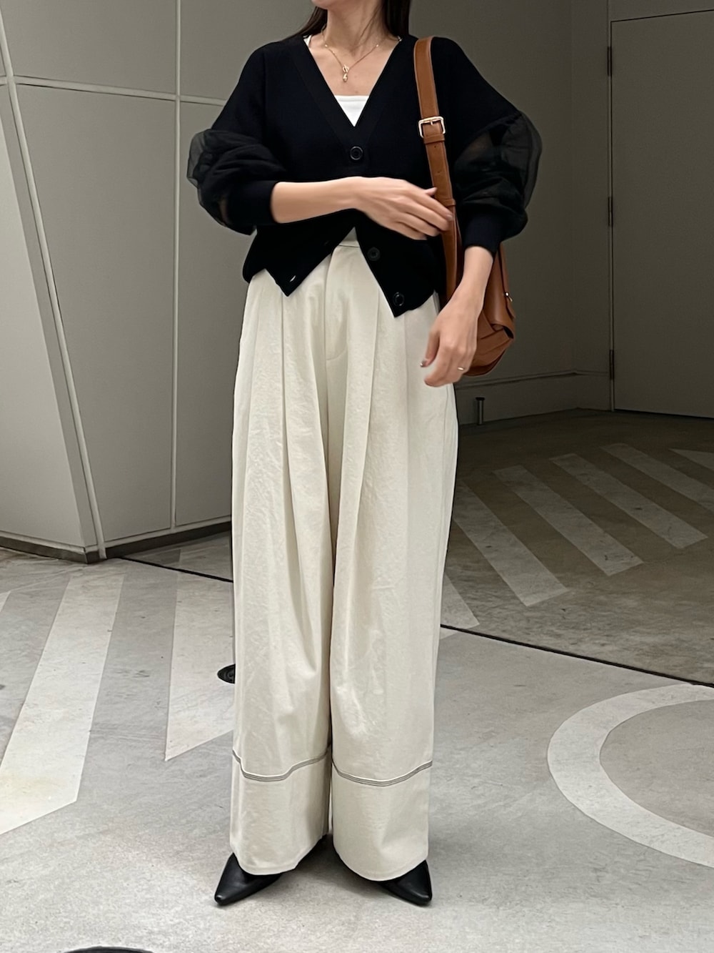 ホワイト系のその他パンツ、ブラック系のカーディガン/ボレロ、ベージュ系のショルダーバッグを着用したレディースの春コーディネートの2枚目の写真