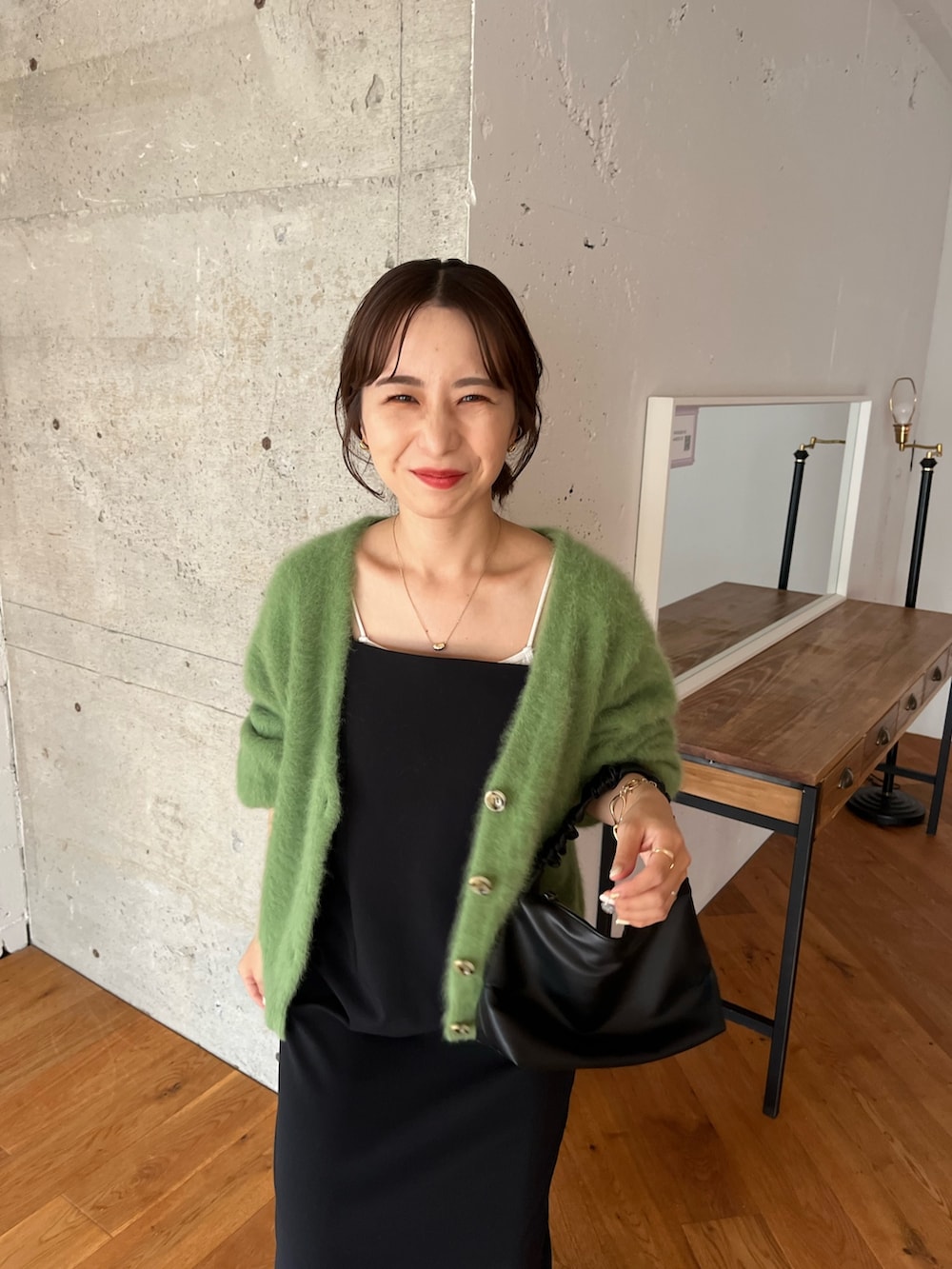 グリーン系のカーディガン/ボレロ、ブラック系のワンピース、ブラック系のハンドバッグを着用したレディースの夏コーディネートの5枚目の写真