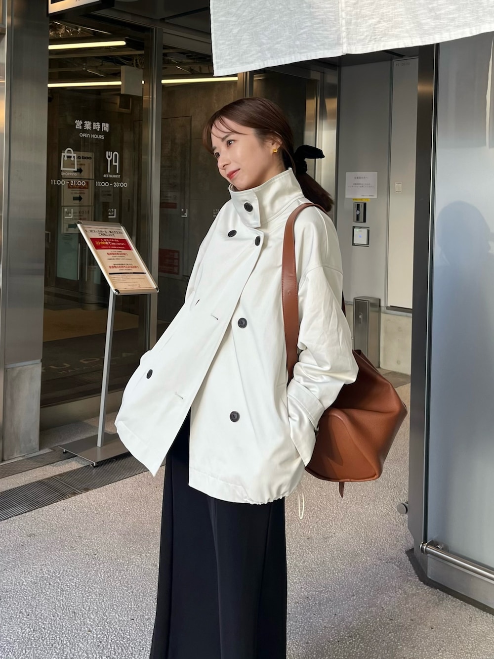 ホワイト系のその他アウター、ブラック系のスカート、イエロー系のショルダーバッグを着用したレディースの冬コーディネートの2枚目の写真