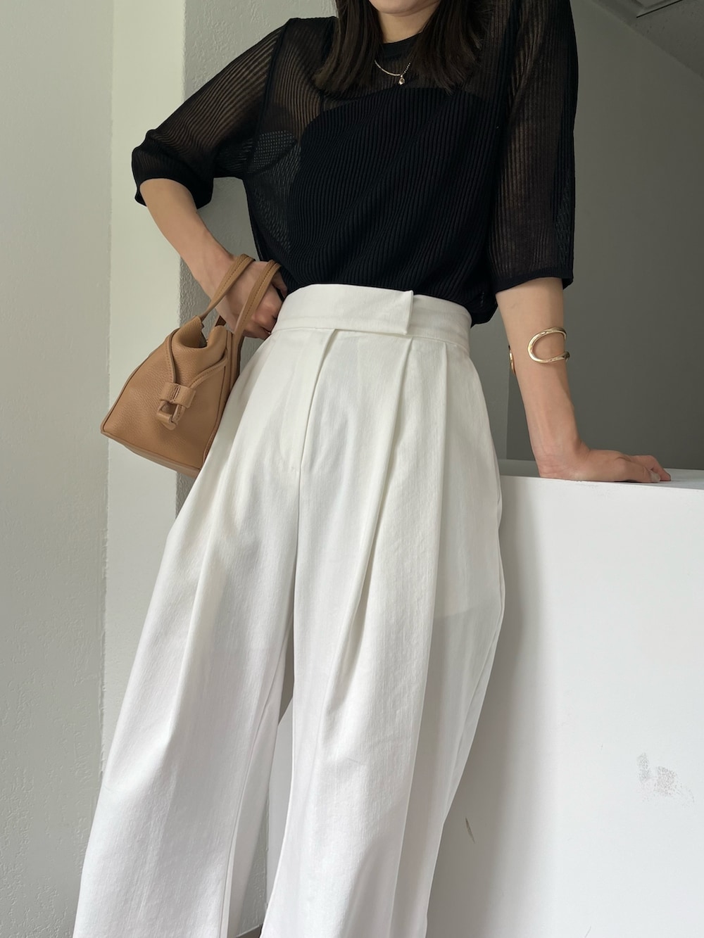 ホワイト系のその他パンツ、ブラック系のニット/セーター、ブラック系のタンクトップを着用したレディースの夏コーディネートの5枚目の写真