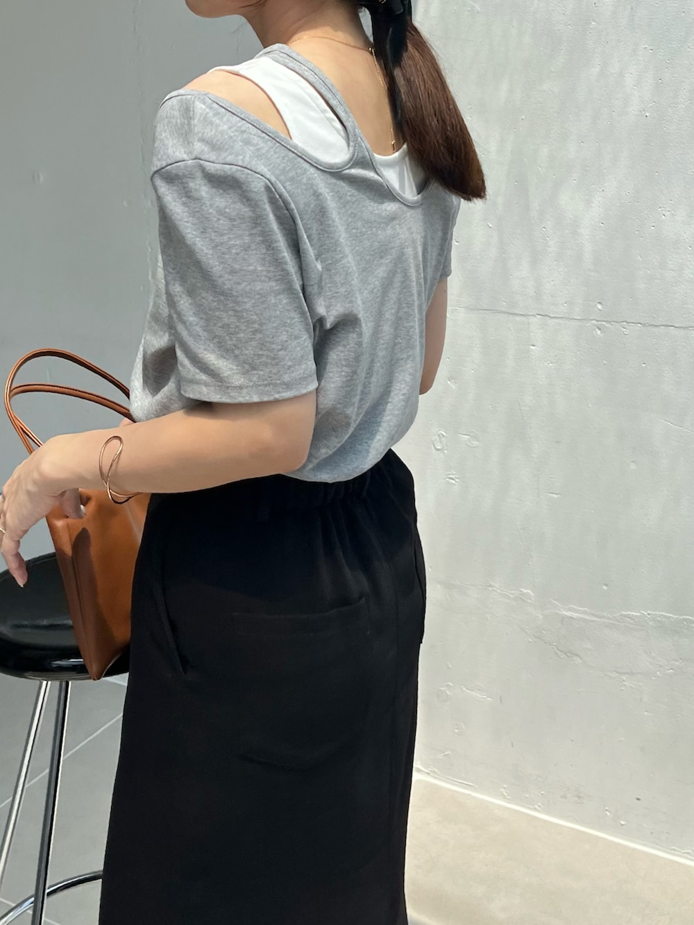 ブラック系のスカート、グレー系のTシャツ/カットソー、ブラック系のサンダルを着用したレディースの夏コーディネートの5枚目の写真