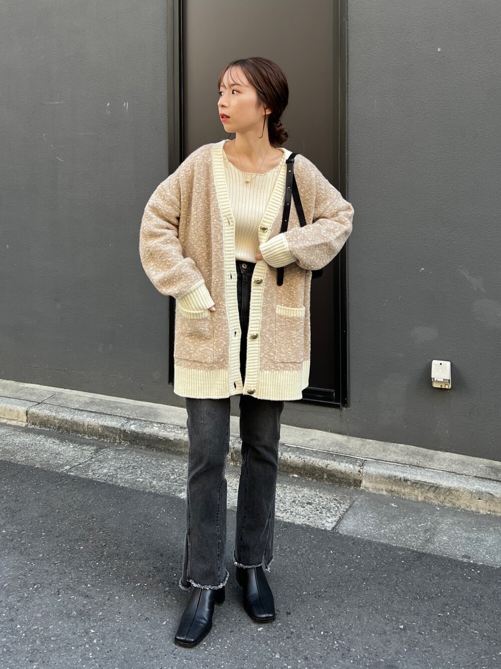 ベージュ系のカーディガン/ボレロ、ホワイト系のニット/セーター、ブラック系のデニムパンツを着用したレディースの秋コーディネートの2枚目の写真