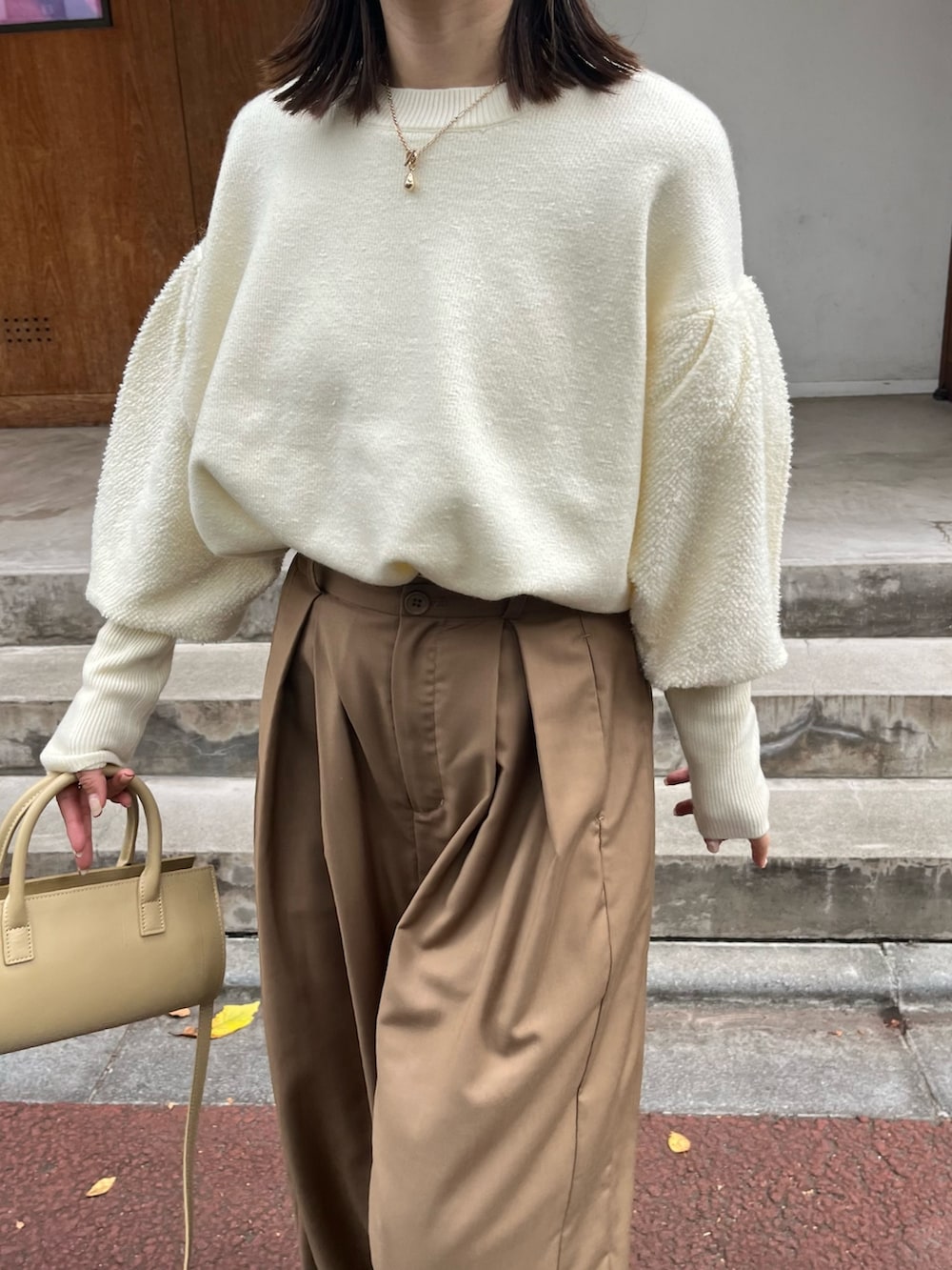 ベージュ系のバッグ、ホワイト系のニット/セーター、ブラウン系のその他パンツを着用したレディースの秋コーディネートの5枚目の写真