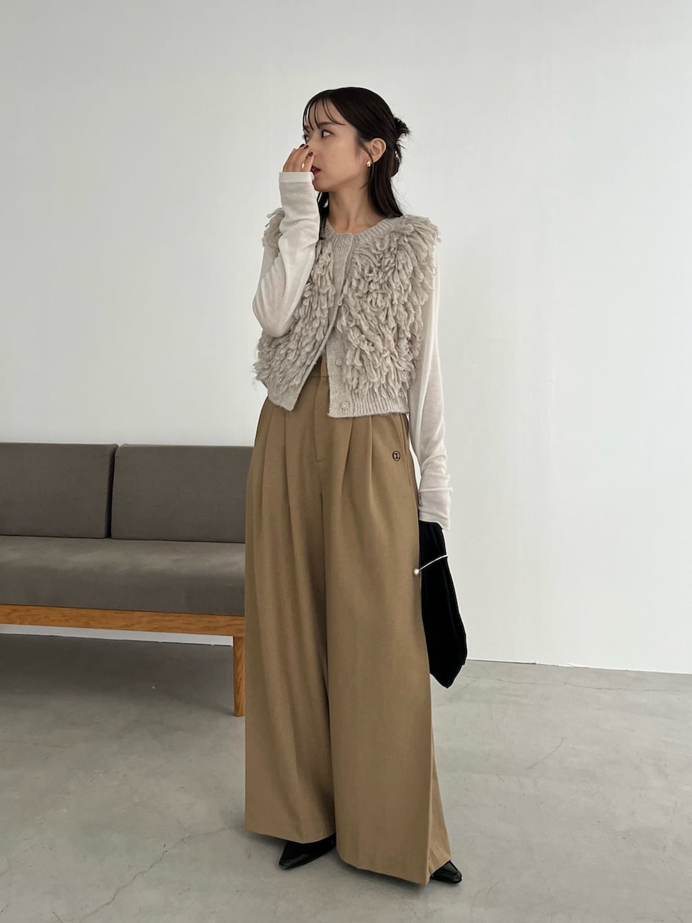 ベージュ系のその他パンツ、ベージュ系のベスト、ホワイト系のTシャツ/カットソーを着用したレディースの冬コーディネートの2枚目の写真