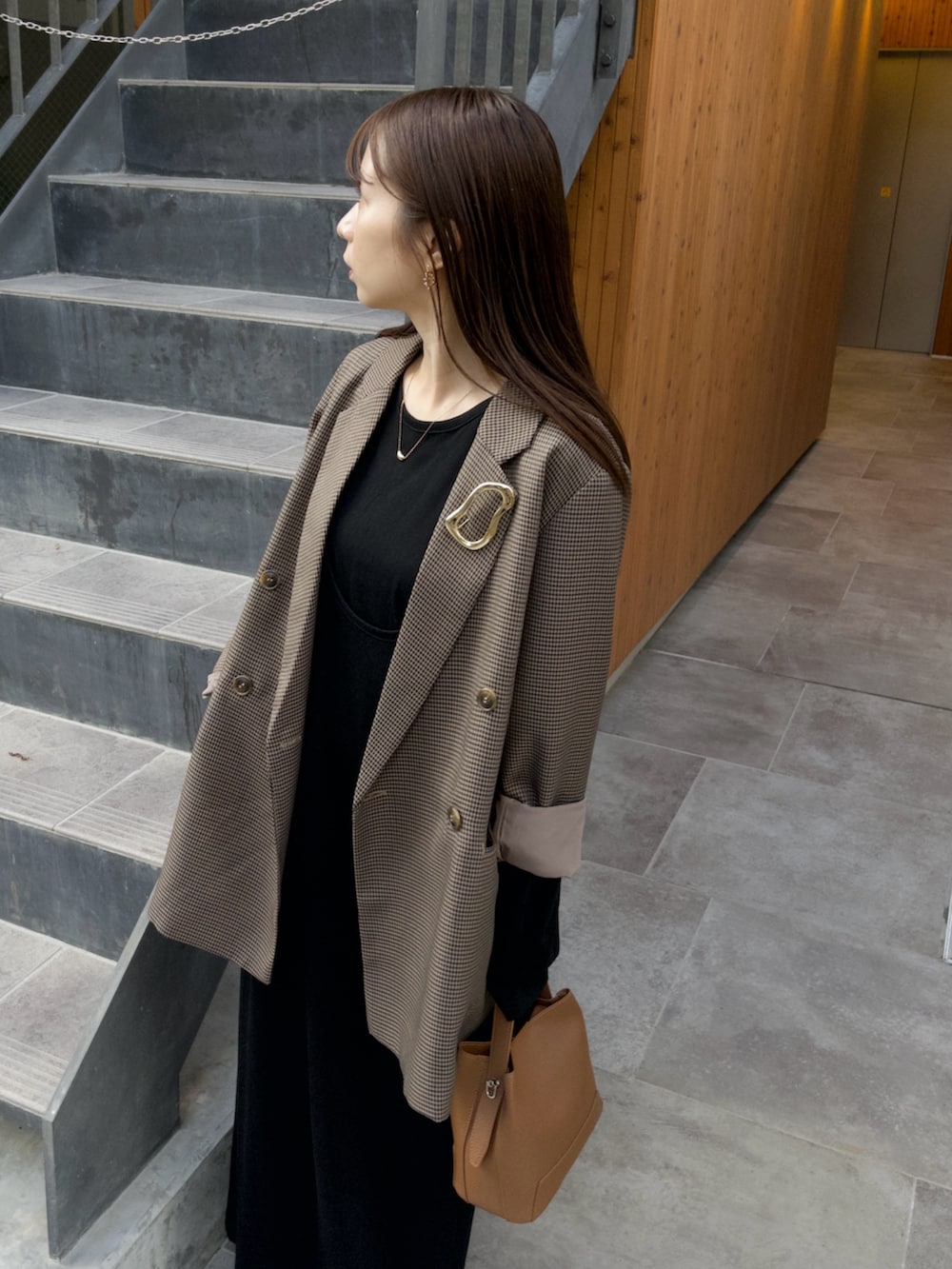ブラック系のワンピース、ブラウン系のテーラードジャケット、ブラウン系のショルダーバッグを着用したレディースの秋コーディネートの3枚目の写真