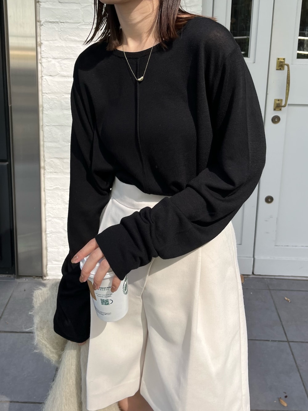 ホワイト系のその他パンツ、ブラック系のニット/セーター、ブラック系のブーツを着用したレディースの秋コーディネートの4枚目の写真