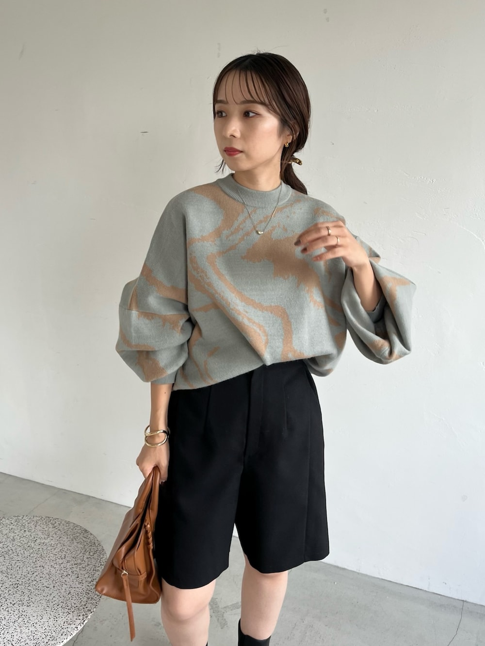 ブラック系のその他パンツ、ブラウン系のトートバッグ、グリーン系のニット/セーターを着用したレディースの秋コーディネートの4枚目の写真