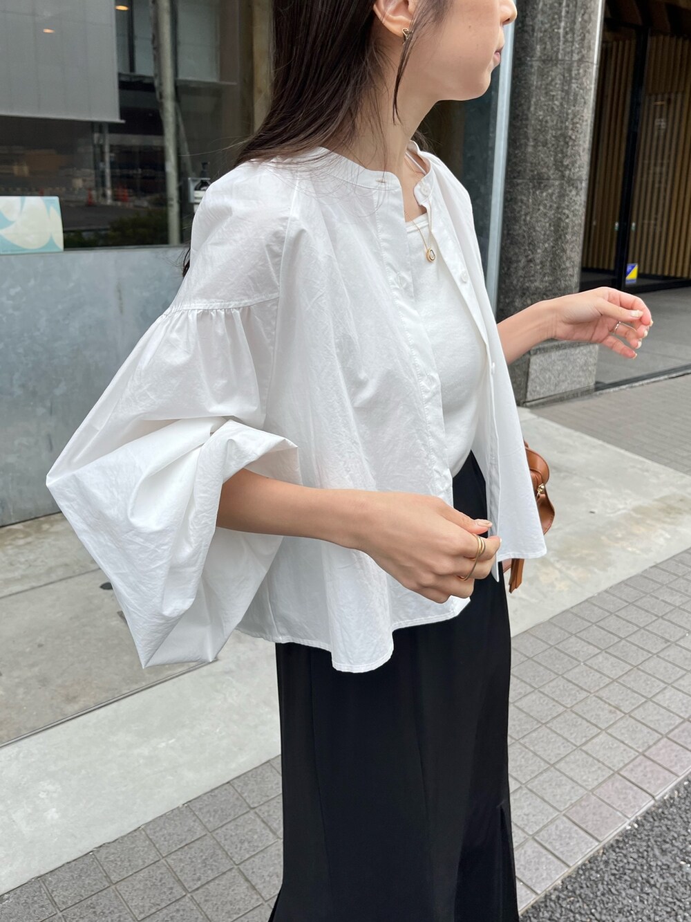 ブラック系のスカート、ホワイト系のシャツ/ブラウス、ブラウン系のトートバッグを着用したレディースの春コーディネートの6枚目の写真