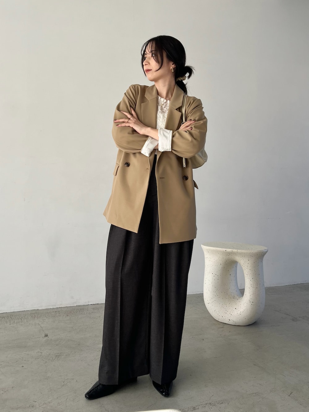 ホワイト系のニット/セーター、ベージュ系のテーラードジャケット、ブラック系のその他パンツを着用したレディースの冬コーディネートの2枚目の写真