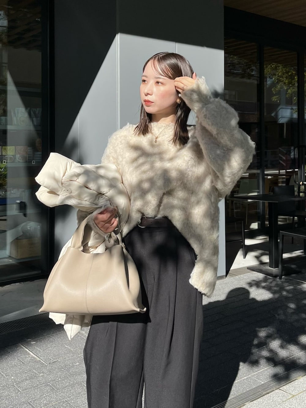 ベージュ系のニット/セーター、ブラック系のスラックス、ブラック系のブーツを着用したレディースの冬コーディネートの4枚目の写真