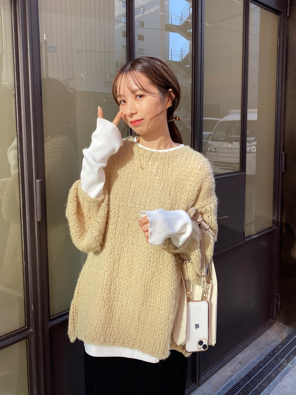 ブラック系のスカート、ベージュ系のニット/セーター、ホワイト系のTシャツ/カットソーを着用したレディースの秋コーディネートの3枚目の写真