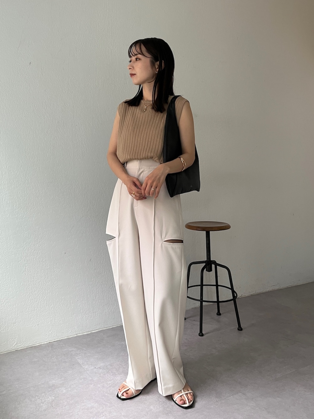ホワイト系のその他パンツ、ベージュ系のニット/セーター、ブラック系のバッグを着用したレディースの夏コーディネートの2枚目の写真