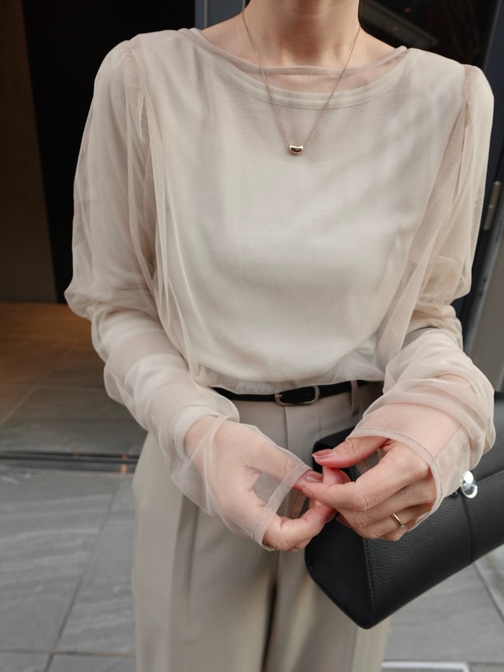 ベージュ系のTシャツ/カットソー、ベージュ系のその他パンツ、ブラック系のハンドバッグを着用したレディースの春コーディネートの2枚目の写真