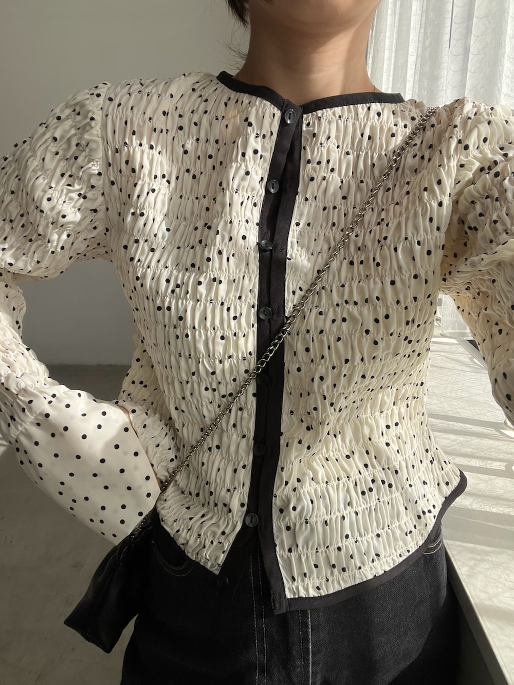 ホワイト系のシャツ/ブラウス、ブラック系のデニムパンツ、ブラック系のショルダーバッグを着用したレディースの冬コーディネートの3枚目の写真