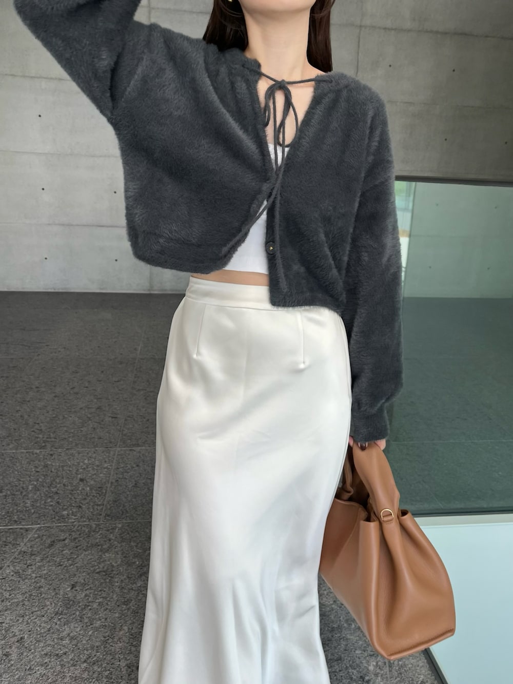 ホワイト系のスカート、ブラウン系のバッグ、グレー系のカーディガン/ボレロを着用したレディースの秋コーディネートの3枚目の写真