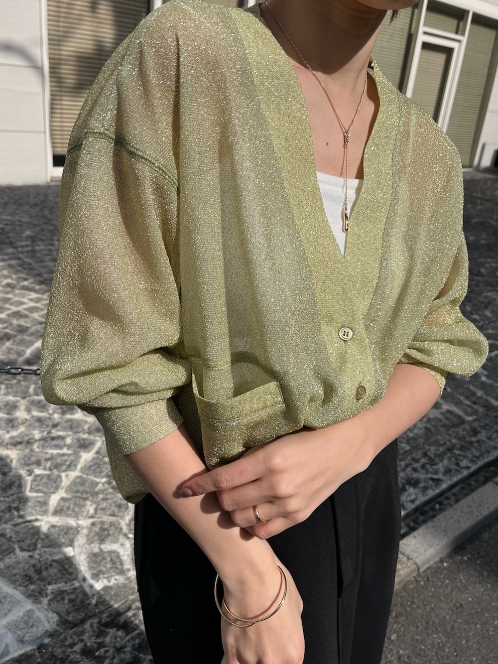 ブラック系のスカート、ホワイト系のハンドバッグ、ブラック系のブーツを着用したレディースの春コーディネートの3枚目の写真