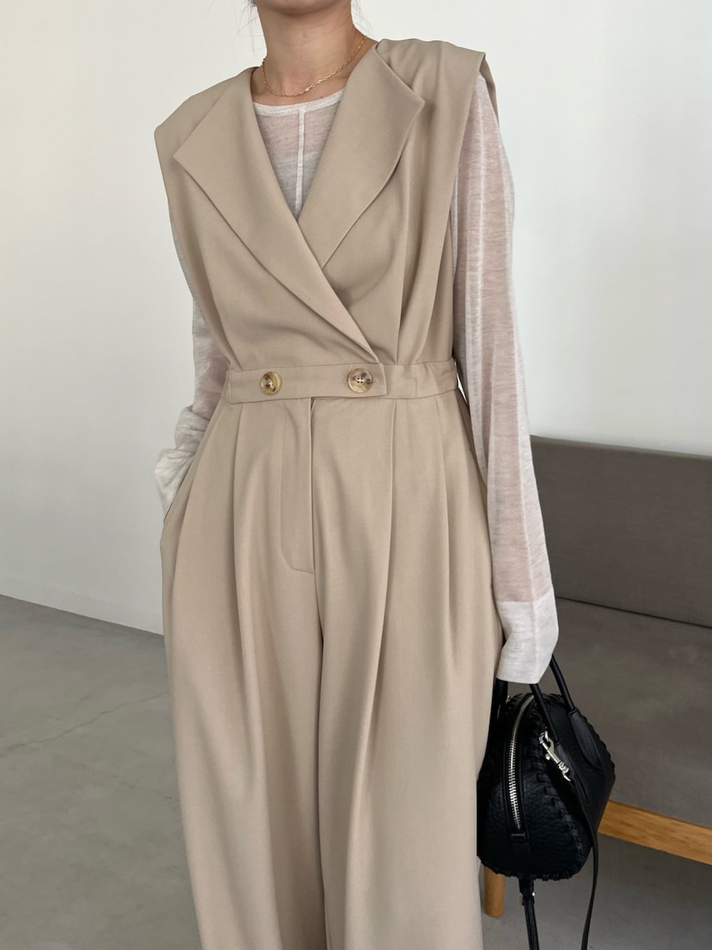 ブラック系のパンプス、ホワイト系のニット/セーター、ベージュ系のつなぎ/オールインワンを着用したレディースの冬コーディネートの4枚目の写真