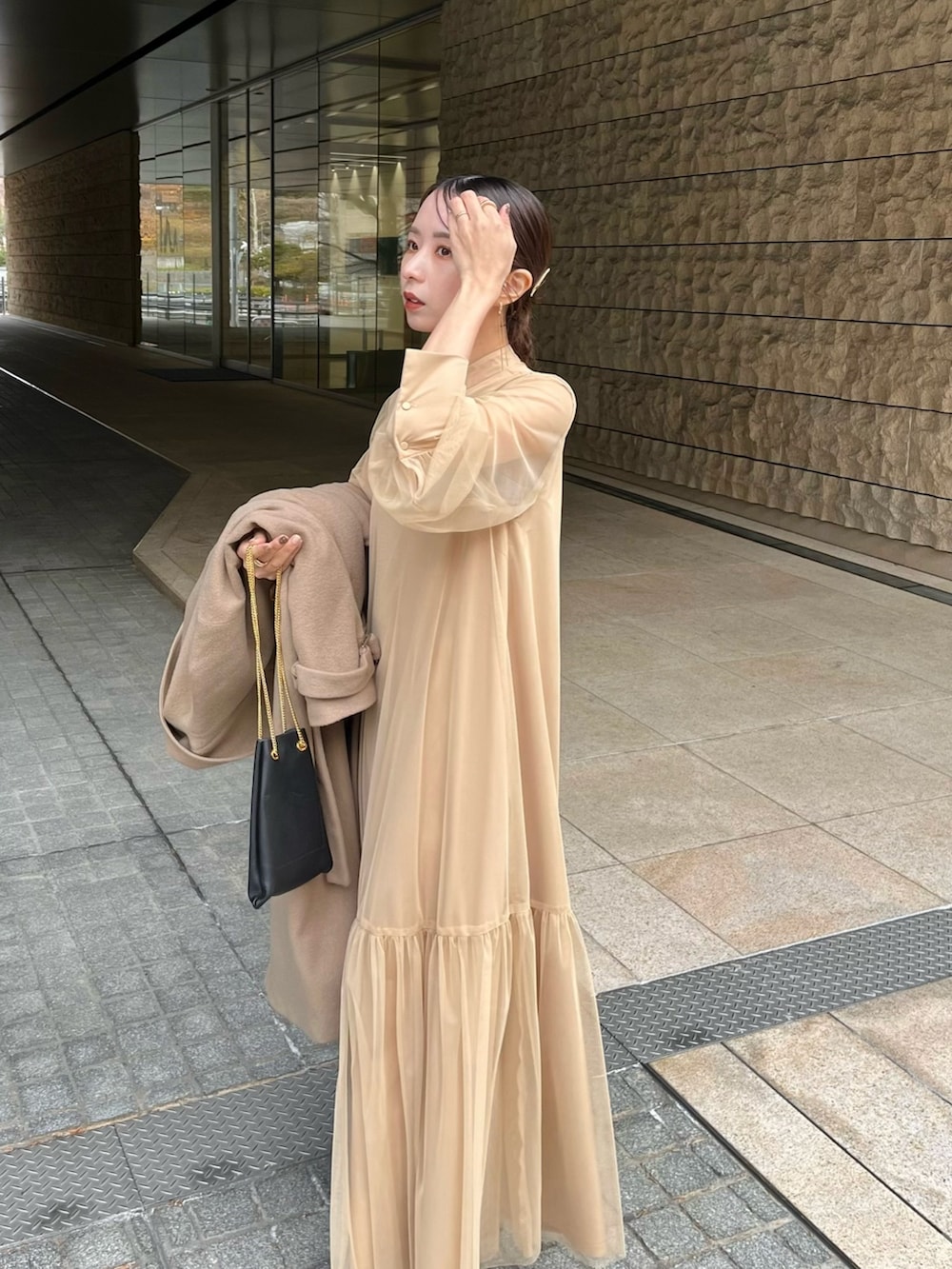 ベージュ系のワンピース、ブラック系のショルダーバッグ、ブラック系のパンプスを着用したレディースの冬コーディネートの5枚目の写真