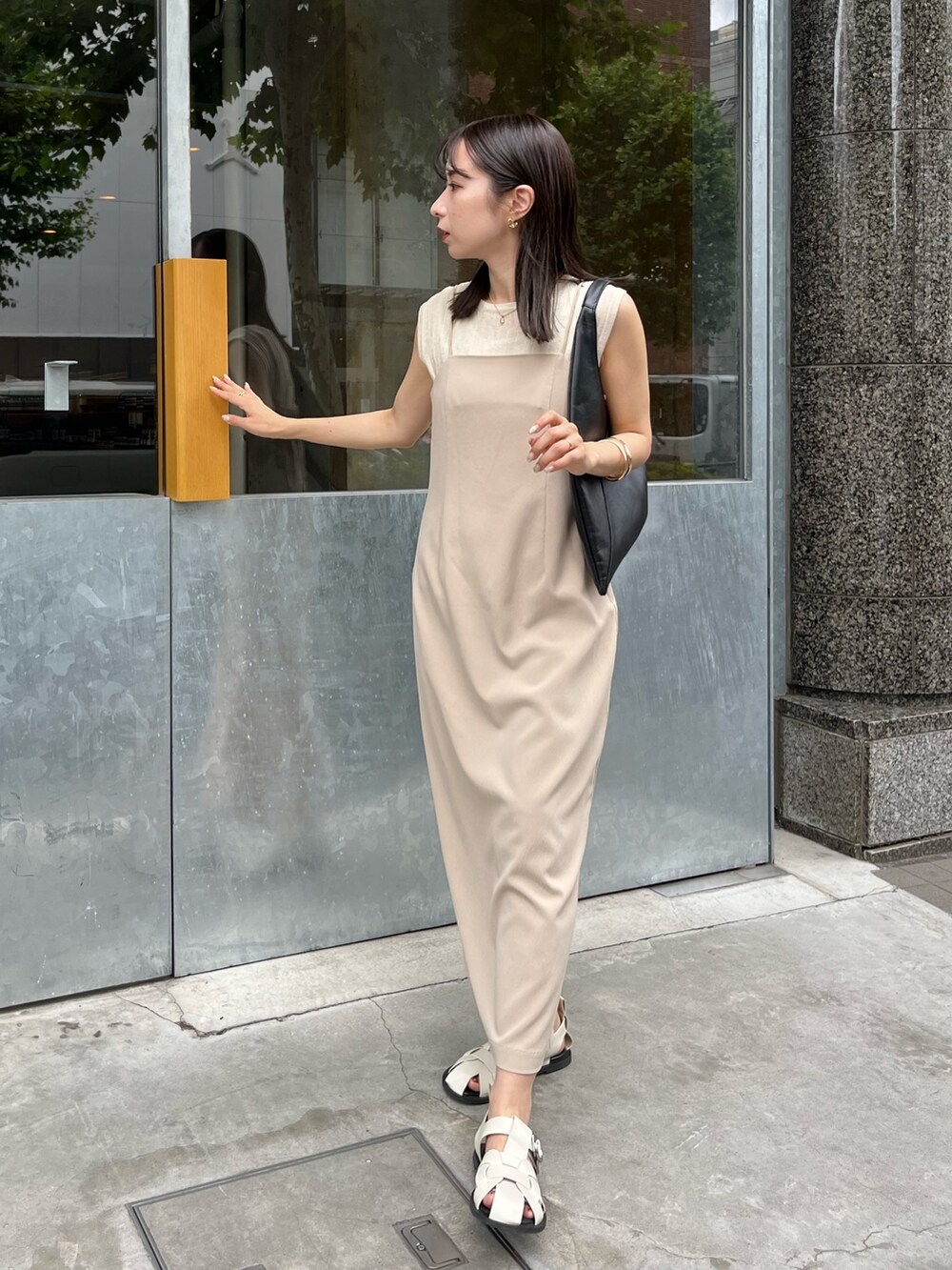 ベージュ系のワンピース、ブラック系のバッグ、ホワイト系のニット/セーターを着用したレディースの夏コーディネートの3枚目の写真