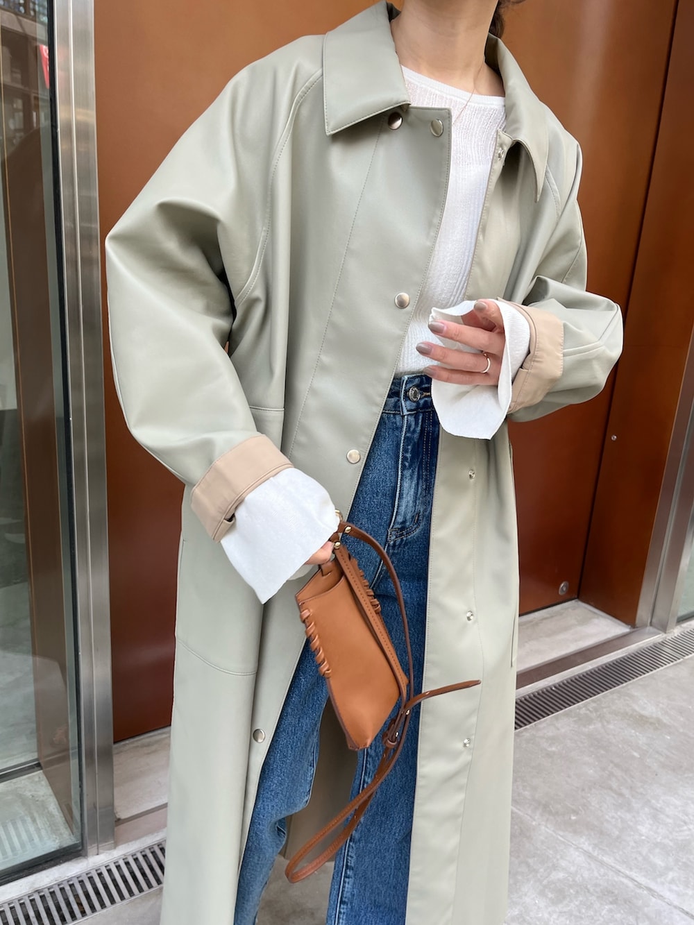 ブルー系のデニムパンツ、グリーン系のその他アウター、ホワイト系のニット/セーターを着用したレディースの冬コーディネートの3枚目の写真