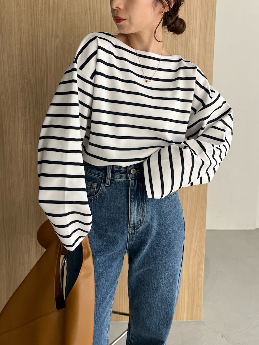 ホワイト系のニット/セーター、ブルー系のデニムパンツ、ブラック系のサンダルを着用したレディースの冬コーディネートの5枚目の写真