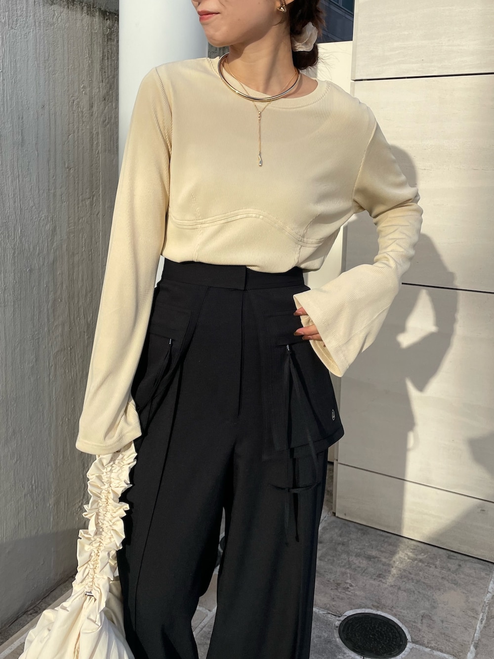 ブラック系のその他パンツ、ブラック系のパンプス、ベージュ系のTシャツ/カットソーを着用したレディースの冬コーディネートの7枚目の写真