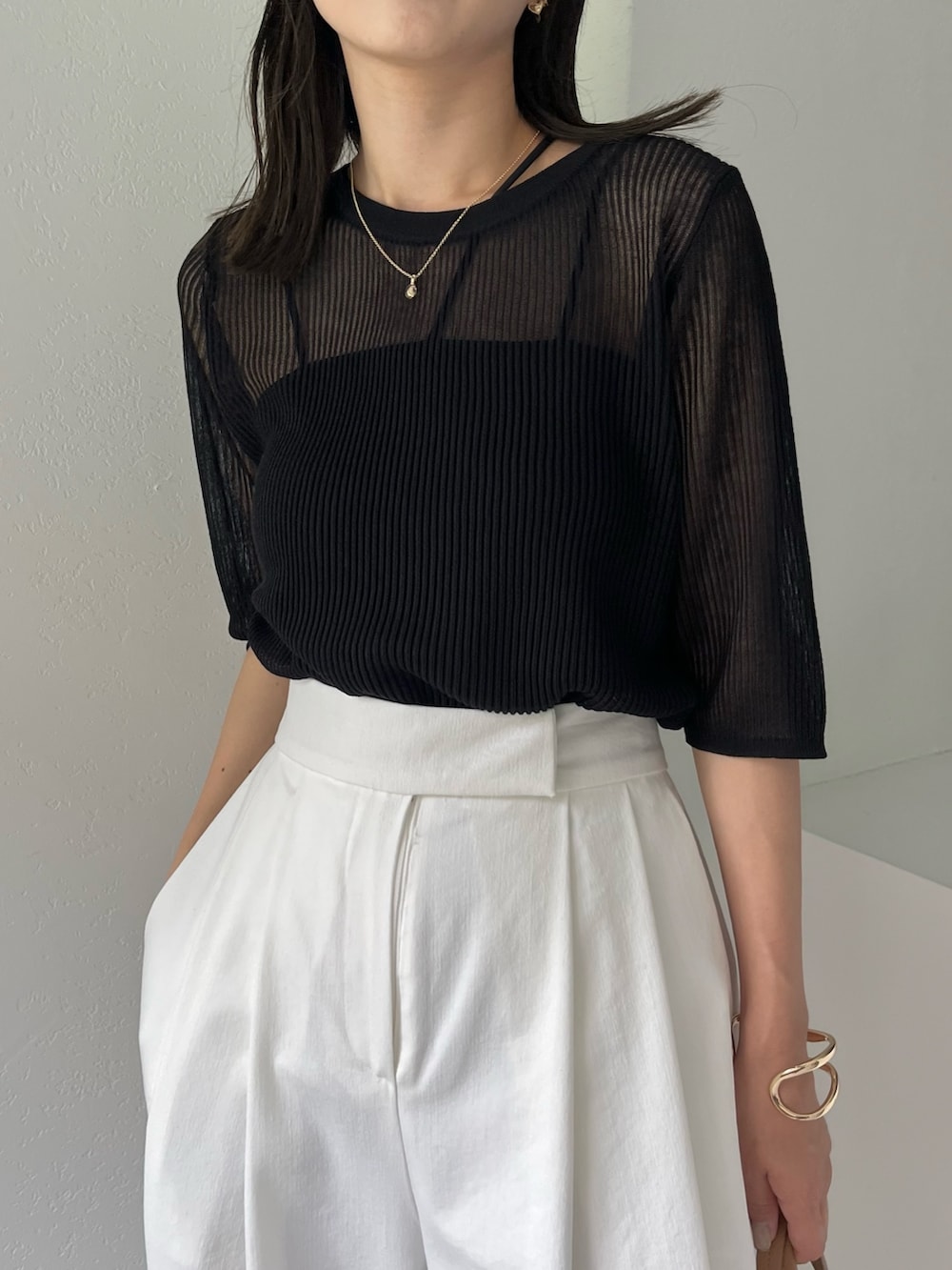 ホワイト系のその他パンツ、ブラック系のニット/セーター、ブラック系のタンクトップを着用したレディースの夏コーディネートの6枚目の写真