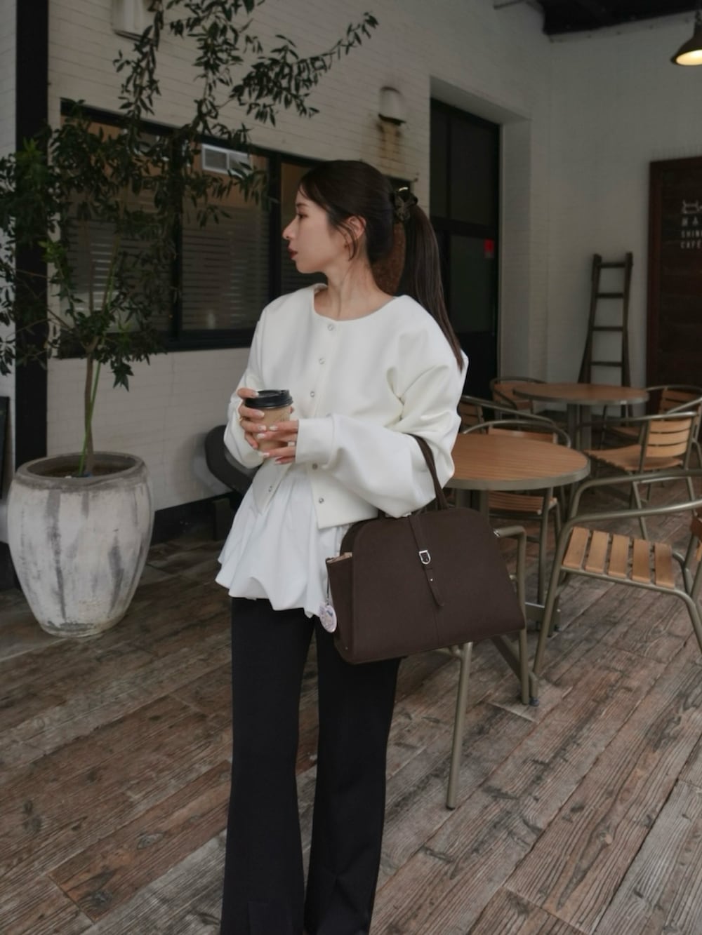 ホワイト系のTシャツ/カットソー、ホワイト系のTシャツ/カットソー、ブラウン系のバッグを着用したレディースの冬コーディネートの2枚目の写真