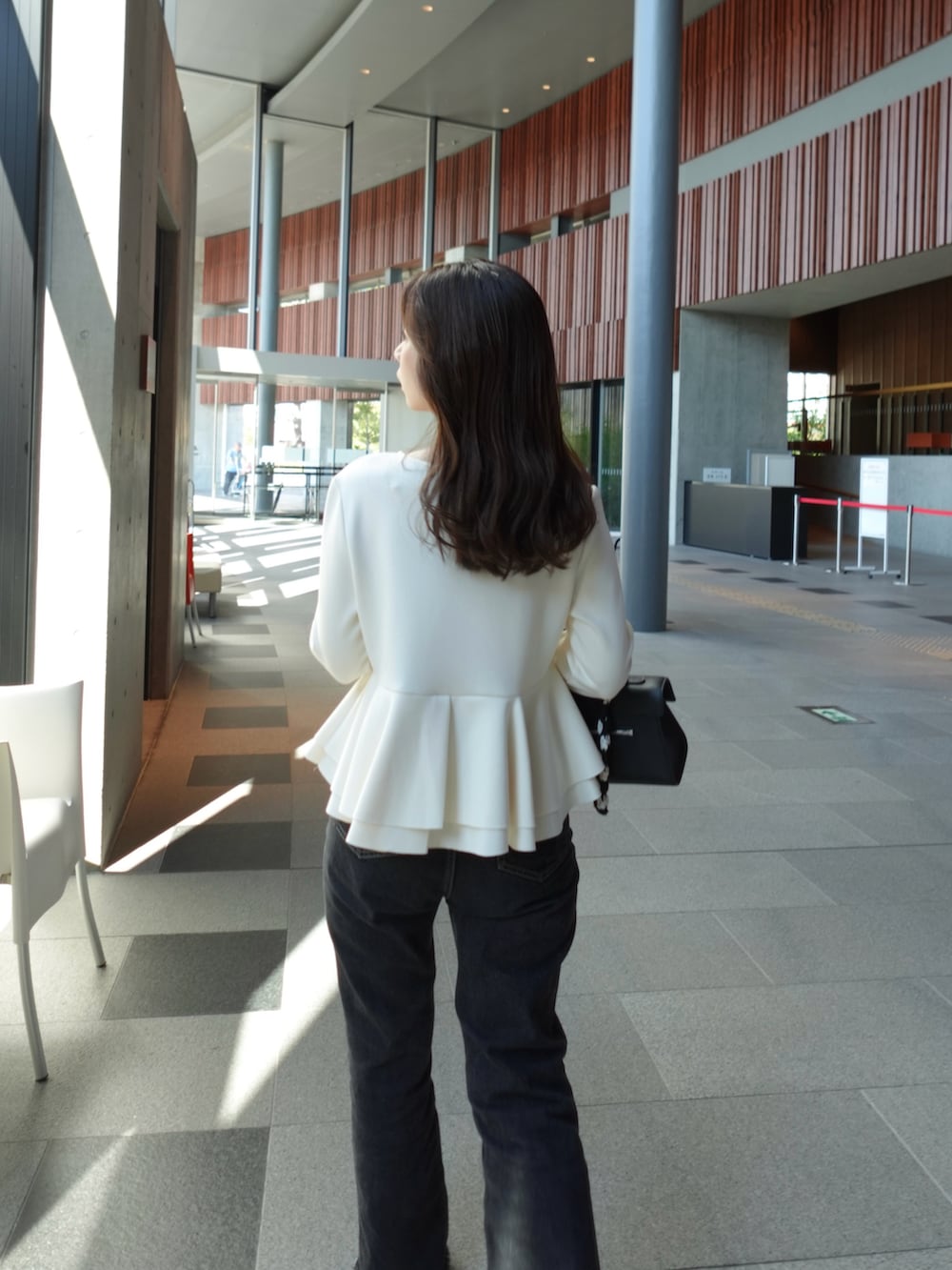 ホワイト系のTシャツ/カットソー、ブラック系のデニムパンツ、ブラック系のバレエシューズを着用したレディースの秋コーディネートの5枚目の写真