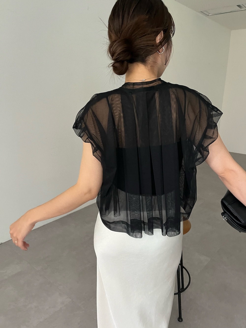 ホワイト系のスカート、ブラック系のシャツ/ブラウス、ブラック系のショルダーバッグを着用したレディースの夏コーディネートの4枚目の写真