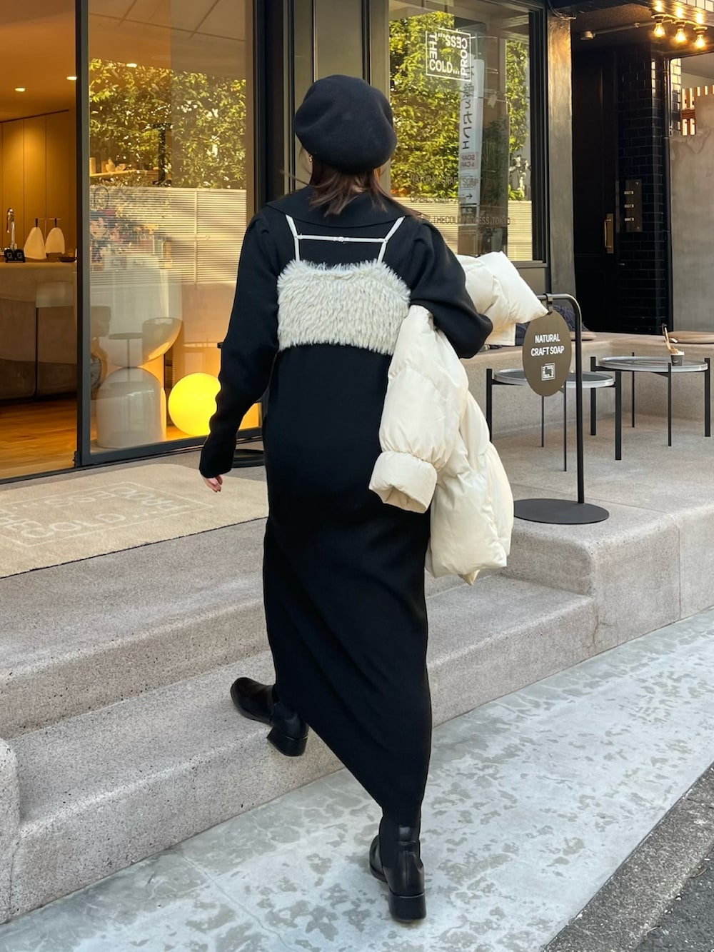 ブラック系のワンピース、ホワイト系のダウンジャケット/コート、グリーン系のトップスを着用したレディースの冬コーディネートの6枚目の写真