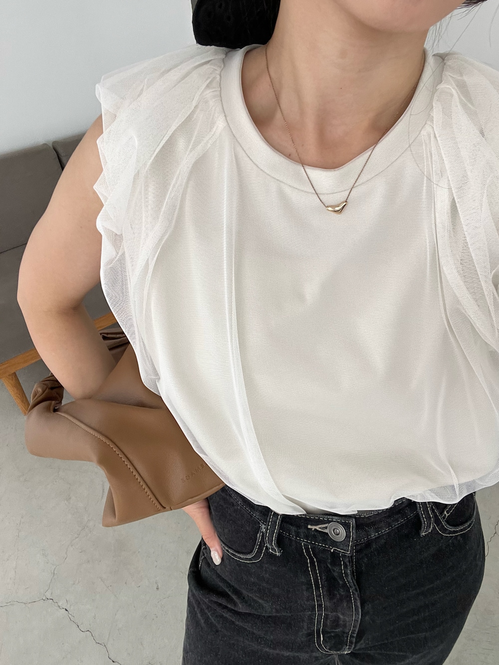 ブラック系のデニムパンツ、イエロー系のショルダーバッグ、ホワイト系のTシャツ/カットソーを着用したレディースの夏コーディネートの4枚目の写真