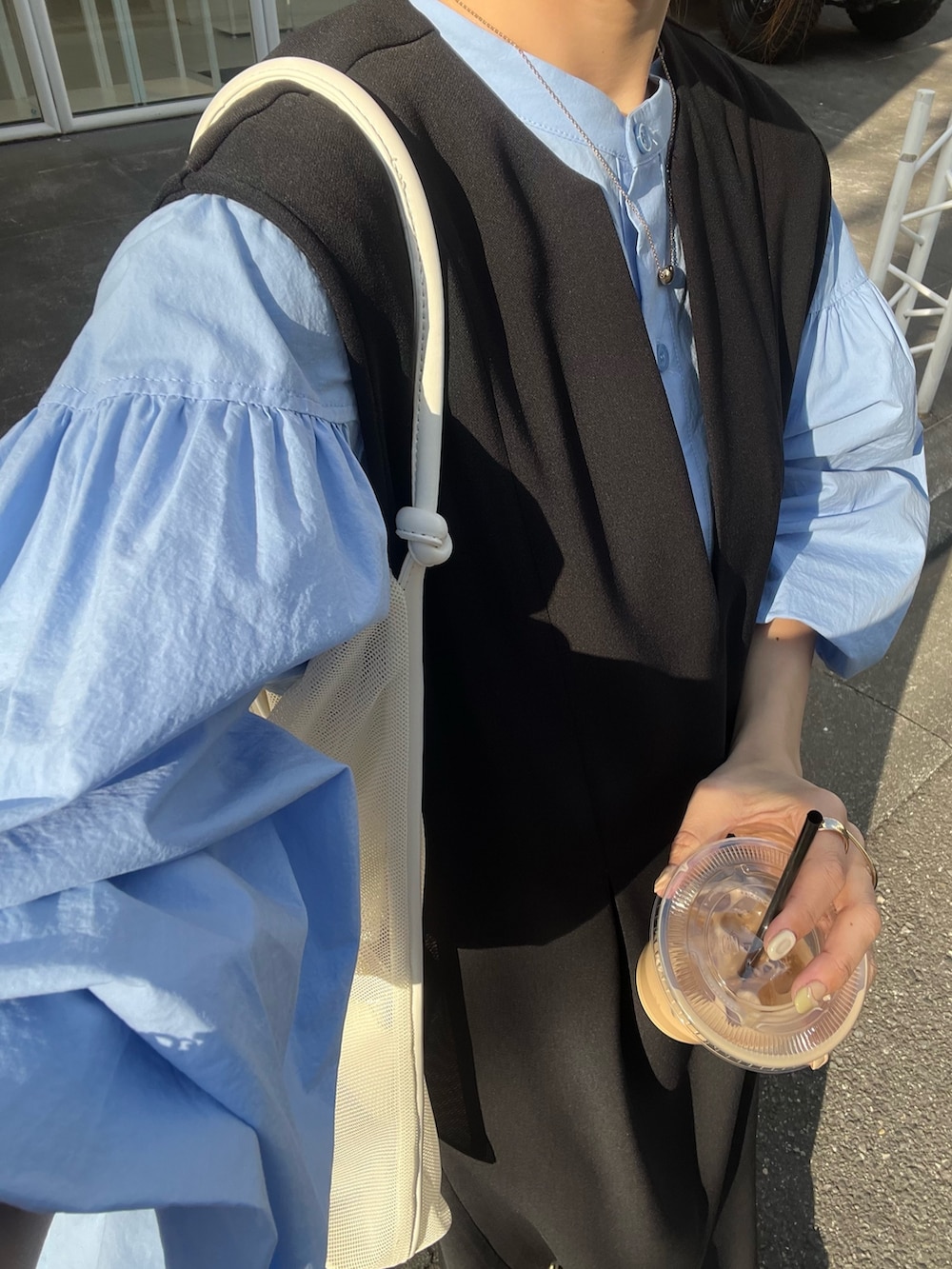 ブラック系のワンピース/ドレス、ブルー系のシャツ/ブラウス、ホワイト系のサンダルを着用したレディースの春コーディネートの6枚目の写真