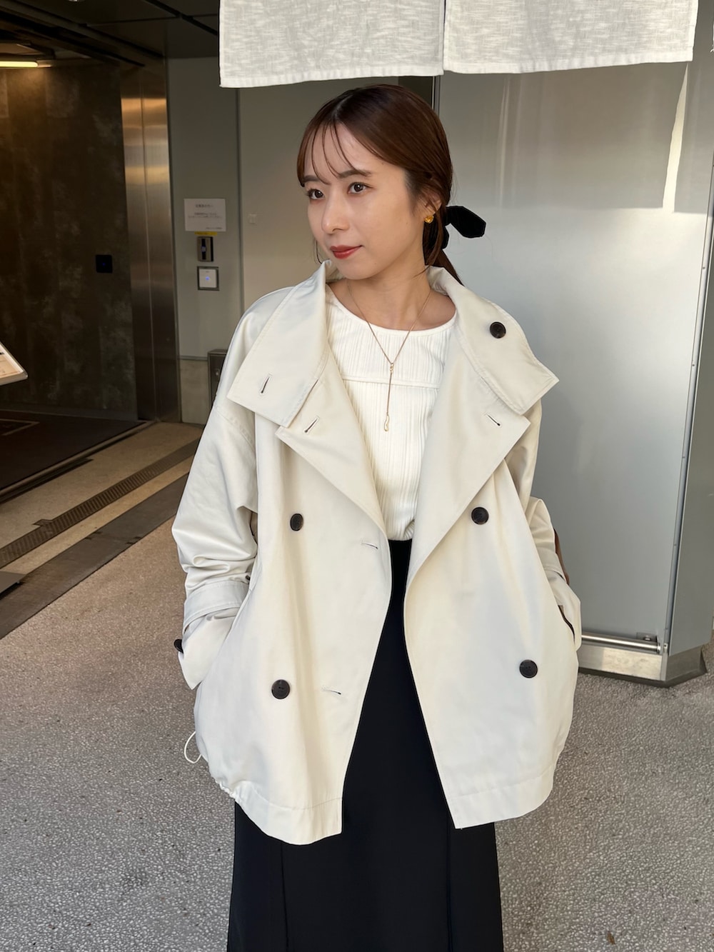 ホワイト系のその他アウター、ブラック系のスカート、イエロー系のショルダーバッグを着用したレディースの冬コーディネートの7枚目の写真